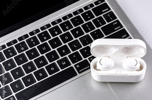 Wireless headphones put on laptop keyboard