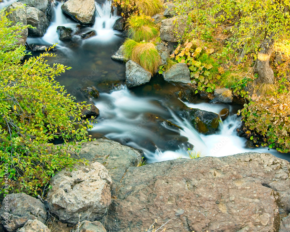 Autumn colors dot the banks along Montgomery Creek as it cascades over both small and large rocks. Autumn colors dot the banks along Montgomery Creek as it cascades over both small and large rocks.