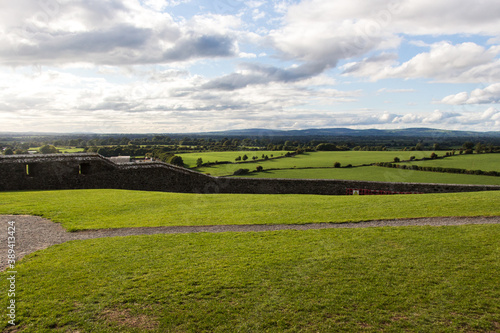 ROCK OF CASHEL, COUNTY TIPPERARY, IRELAND - SEPTEMBER 12, 2018: Green field viewed from Rock of Cashel, also known as Cashel of the Kings and St. Patrick's Rock. Cloudy but sunny sky.