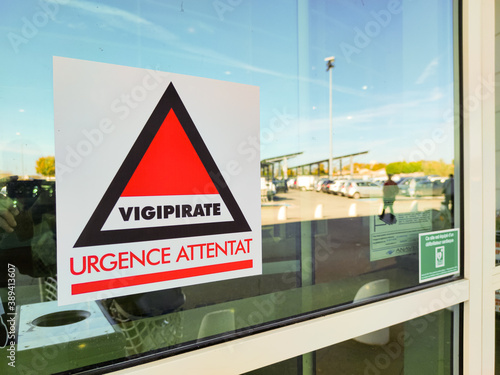 Poster at the entrance of a supermarket displaying Vigipirate, urgence bombat ("Vigipirate, urgence bombat" in french)