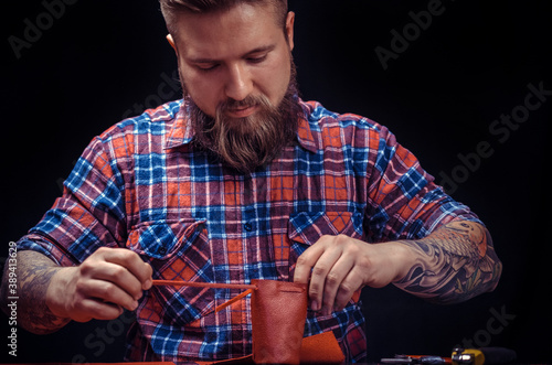 Leather Worker produces leather goods at the leather shop photo