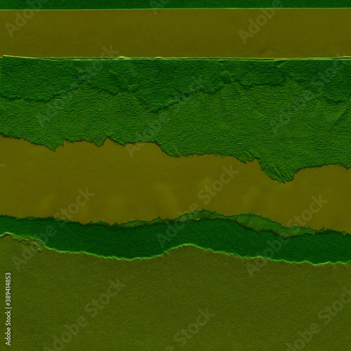 Green torn paper collage close-up. Texture made from various paper and cardboard parts. Damaged old paper background. Vintage blank wallpaper. Material design backdrop.