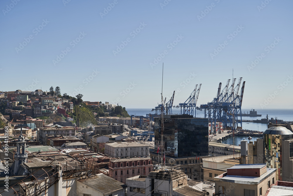 view on the sub urban city scape of valparaiso in chile with the port in the background and tall cranes_1