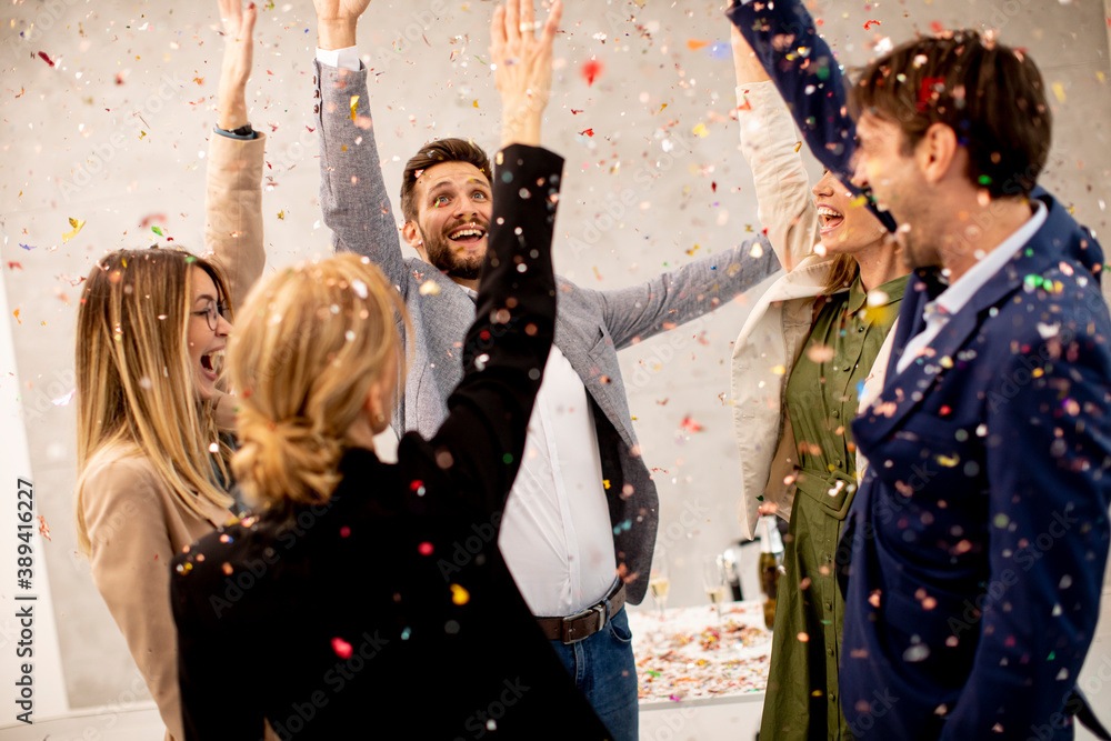 Group of business people celebrating and toasting with confetti falling in the office - obrazy, fototapety, plakaty 
