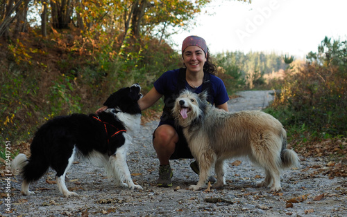 young woman with a couple of dog in the mountains