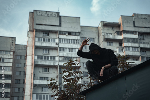 Photos the man in black is sitting on the roof