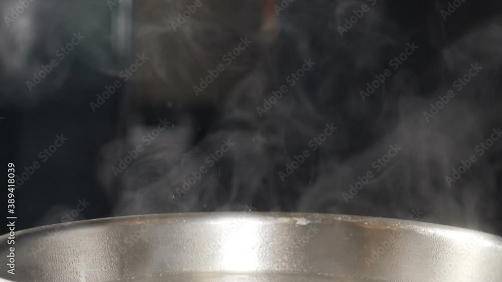 White smoke in slow motion rising above hot frying pan on black background. Cooking in restaurant. Delicious dish being cooked in kitchen. Steam or Vapour clouds. Full hd White smoke in slow motion rising above hot frying pan on black background. Cooking in restaurant. Delicious dish being cooked in kitchen. Steam or Vapour clouds. Full hd