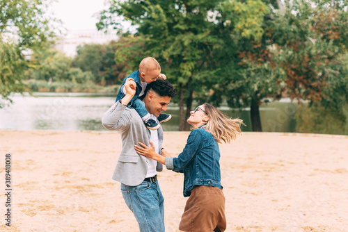 A man and a woman with their son are havin fun in park .