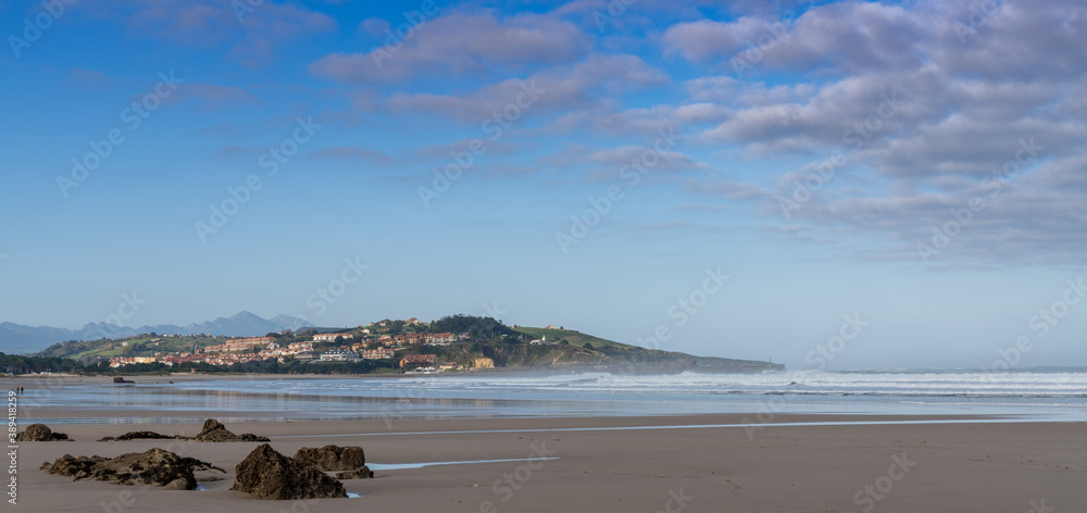 sandy beach panorama landscape with seaside village in the hills behind