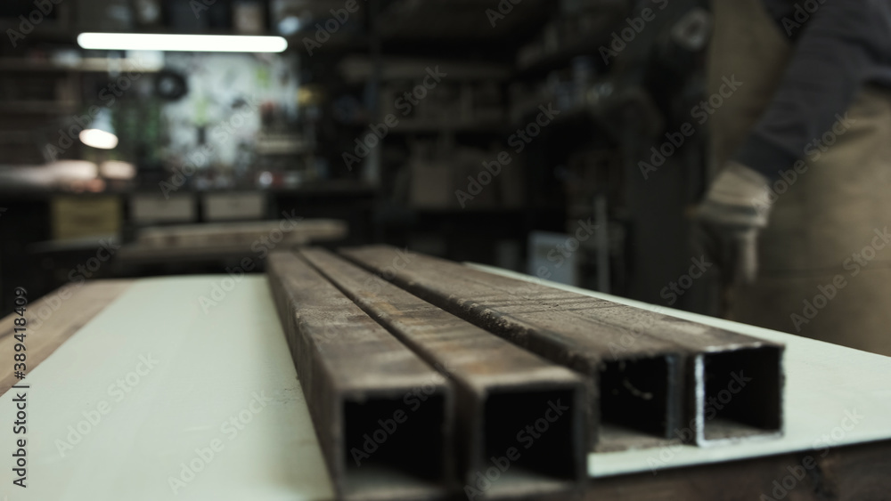 Man works with metal beams in protect gloves. Workshop Man works with metal beams in protect gloves. Workshop