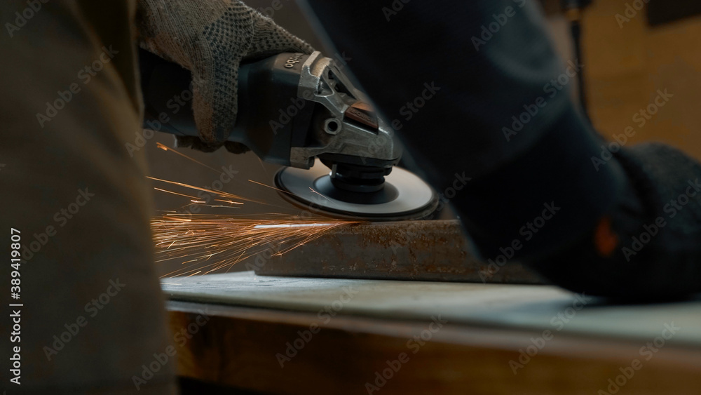 A man in gloves cuts metal with a circular saw, a lot of sparks. The working process A man in gloves cuts metal with a circular saw, a lot of sparks. The working process