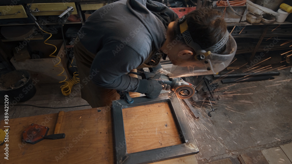 A man in gloves cuts metal with a circular saw, a lot of sparks. The working process A man in gloves cuts metal with a circular saw, a lot of sparks. The working process