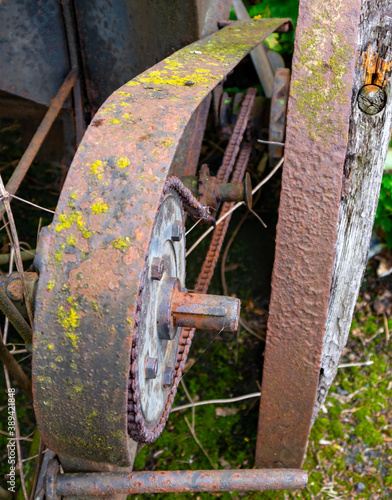 Detail einer alten verrosteten bäuerlichen Saatmaschine, Kettenritzel mit Abdeckung photo