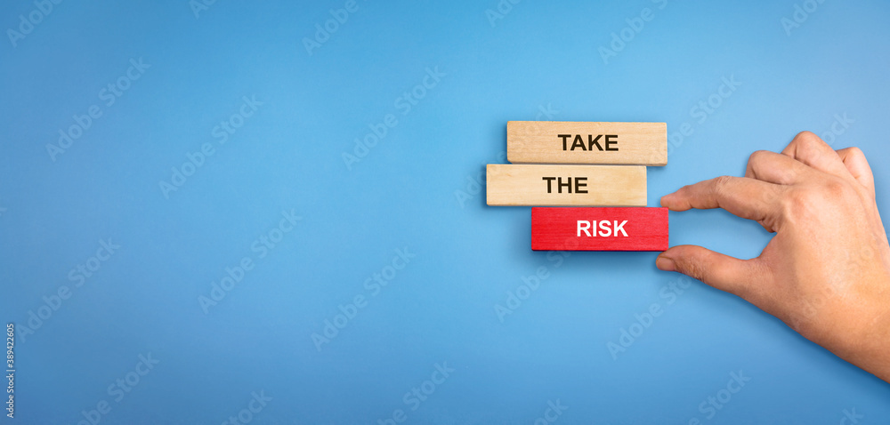 Risk concept. Wooden blocks with text Take the Risk. Hand holding risk ...