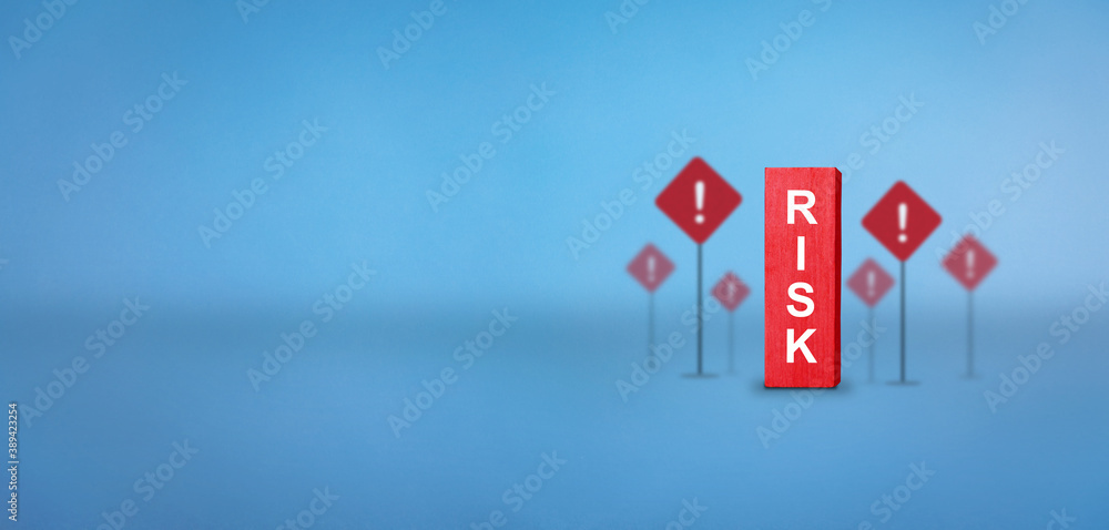 Risk text on wooden red block with risk icon at background. Risk