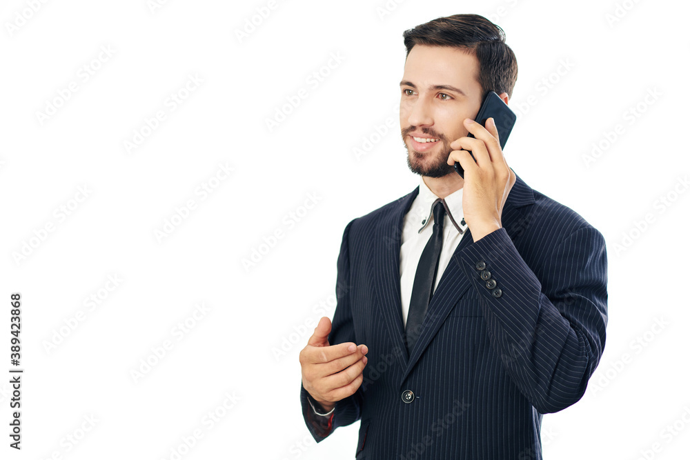 Handsome young businessman in suit smiling when talking on phone with colleague or client Handsome young businessman in suit smiling when talking on phone with colleague or client