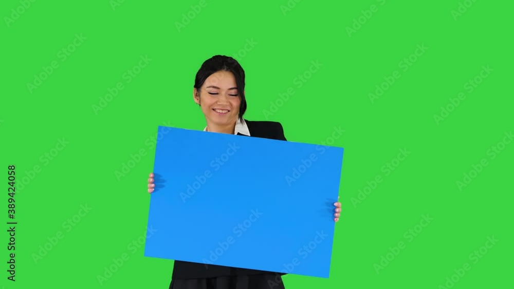 A stylish woman dancing and holding empty poster on a Green Screen, Chroma Key. A stylish woman dancing and holding empty poster on a Green Screen, Chroma Key.