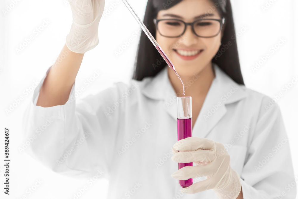 Young Asian scientist woman holding and looking at the chemical flasks in the laboratory Young Asian scientist woman holding and looking at the chemical flasks in the laboratory