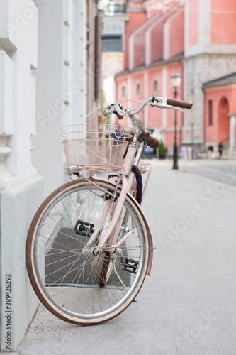 Vintage pink bycicle parked on the city street