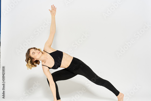 Woman in sportswear is engaged in fitness indoor gymnastics slim figure