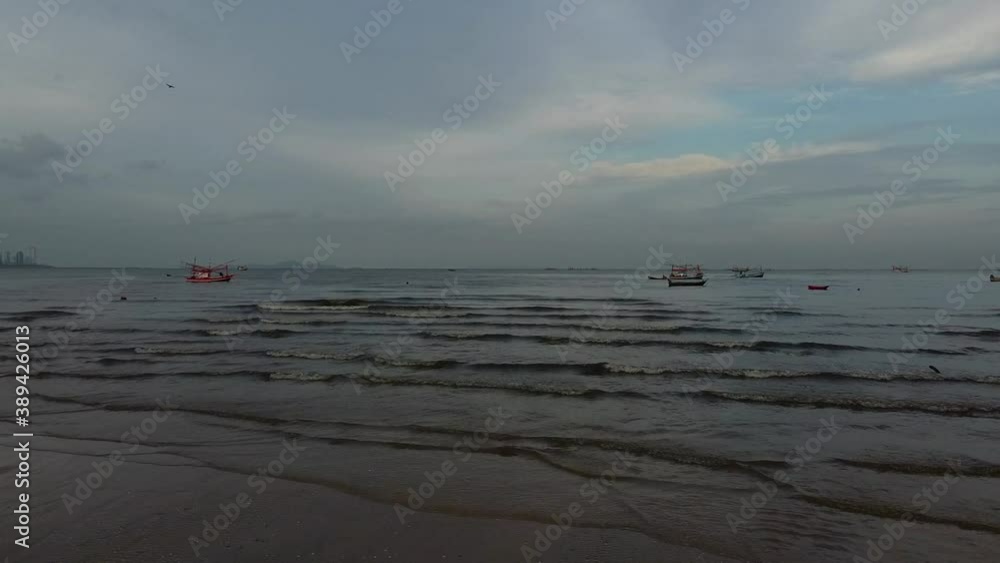 Fly low over sea towards Asian fishermen in small boat at daybreak Fly low over sea towards Asian fishermen in small boat at daybreak