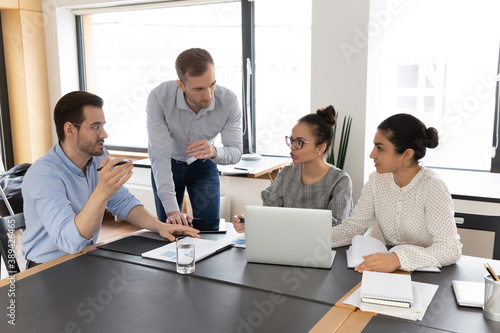 Free Download Concentrated young multiracial diverse colleagues discussing business problems solution, developing project growth strategy at brainstorming meeting or analyzing marketing research results in office. - GFXLoad