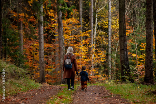 mother and son walk through the forest in autumn © Masson