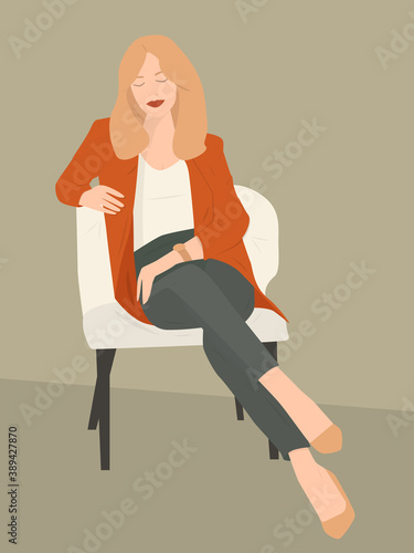 Indoor portrait of amazing young girl with short blond wavy hair and full red lips wearing smart red jacket and high heel shoes sitting in the stylish armchair posing for the photoshoot
