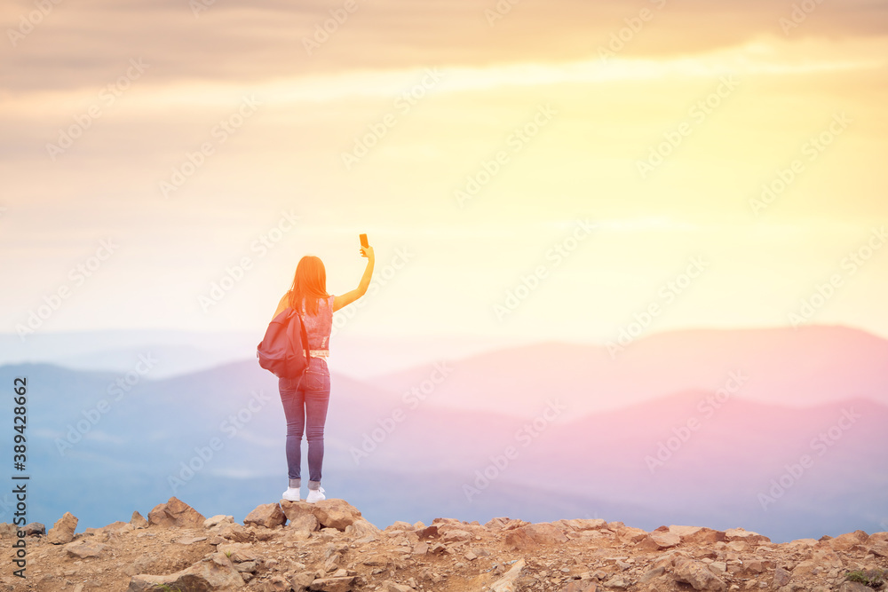 Photographer girl admires sunsets, successful takes photo on travel tour with camera, back view Photographer girl admires sunsets, successful takes photo on travel tour with camera, back view