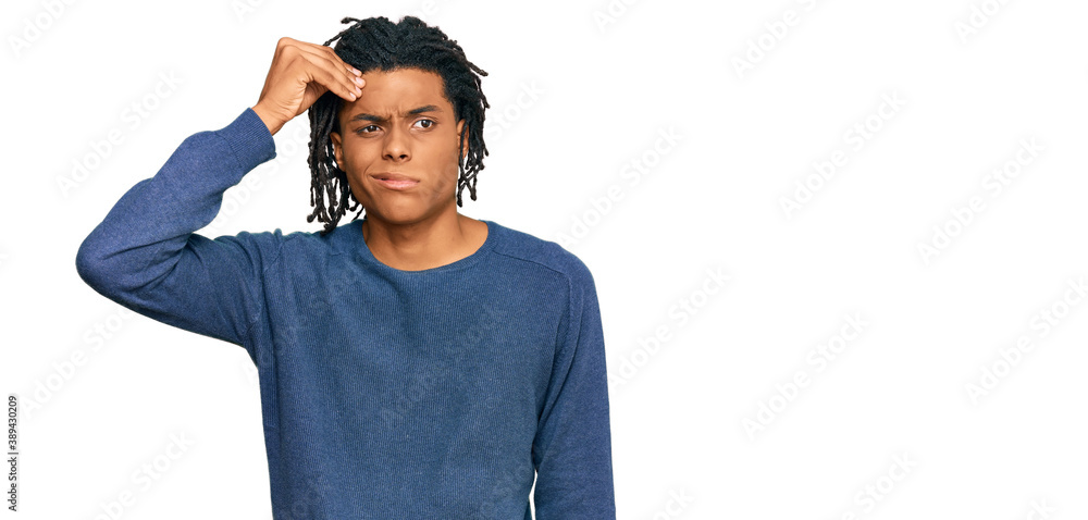 Young african american man wearing casual winter sweater worried and stressed about a problem with hand on forehead, nervous and anxious for crisis Young african american man wearing casual winter sweater worried and stressed about a problem with hand on forehead, nervous and anxious for crisis