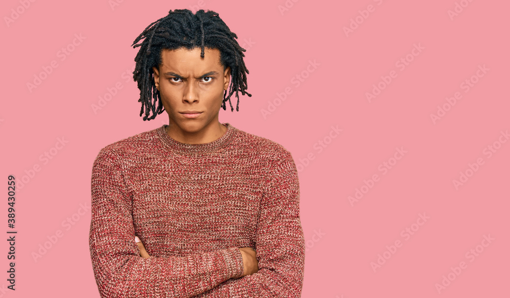 Young african american man wearing casual winter sweater skeptic and nervous, disapproving expression on face with crossed arms. negative person. Young african american man wearing casual winter sweater skeptic and nervous, disapproving expression on face with crossed arms. negative person.
