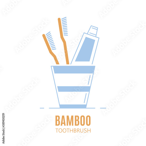 Bamboo toothbrushes and toothpaste tube in a cup