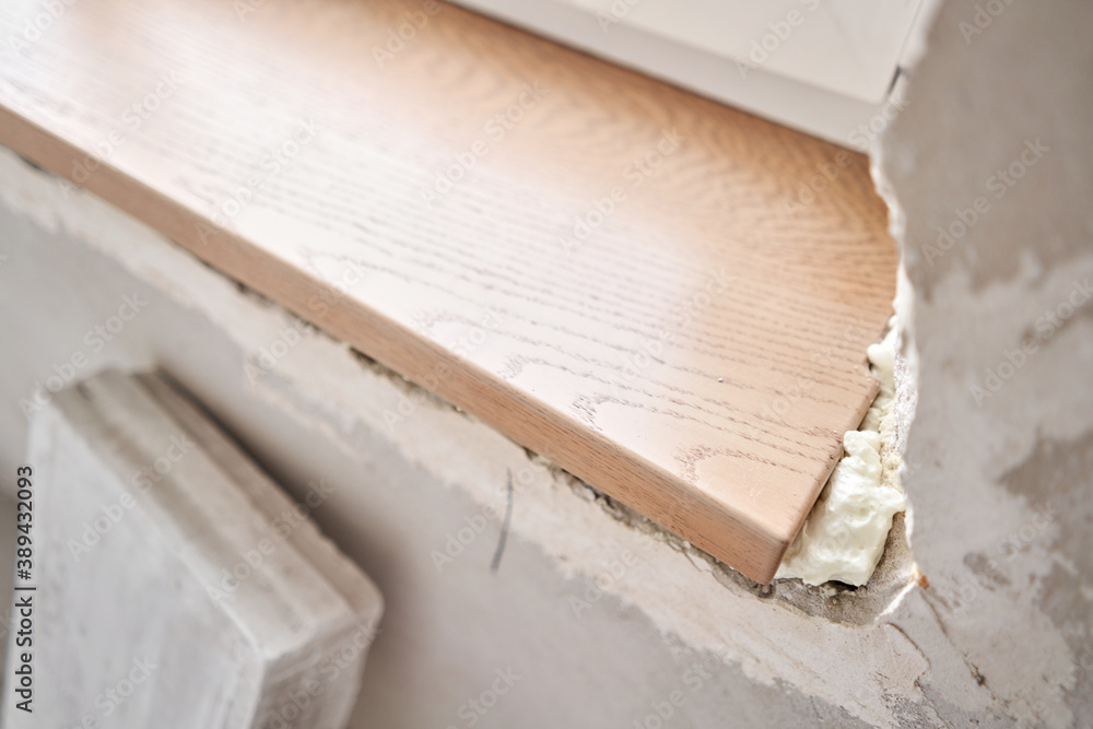 Wooden window sill, plywood covered with oak veneer. Window sill installation process. Interior design, building, home improvement, diy concept. Wooden window sill, plywood covered with oak veneer. Window sill installation process. Interior design, building, home improvement, diy concept.