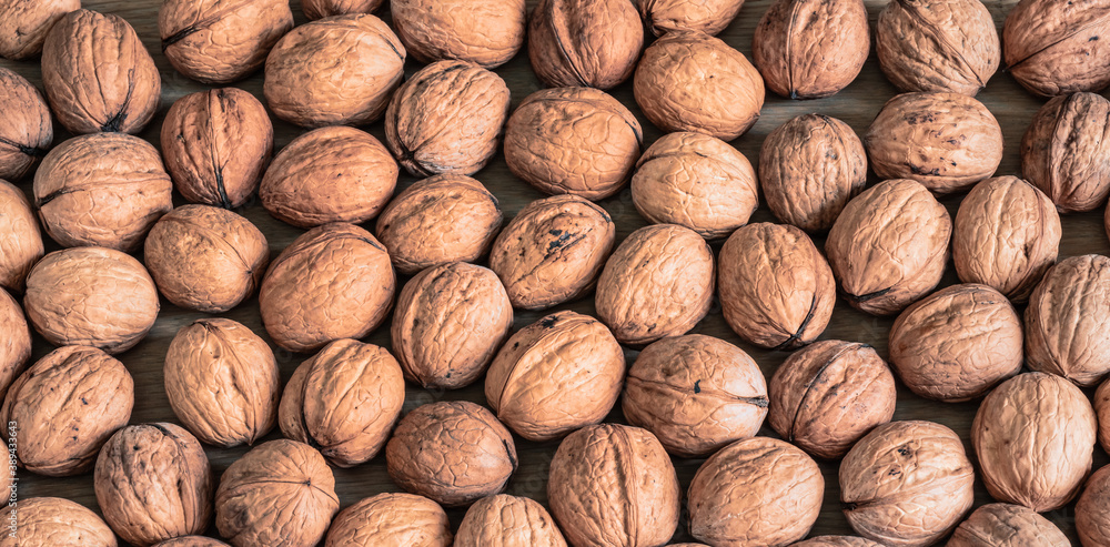Whole brown walnuts with shell. Autumn food background. Whole brown walnuts with shell. Autumn food background.