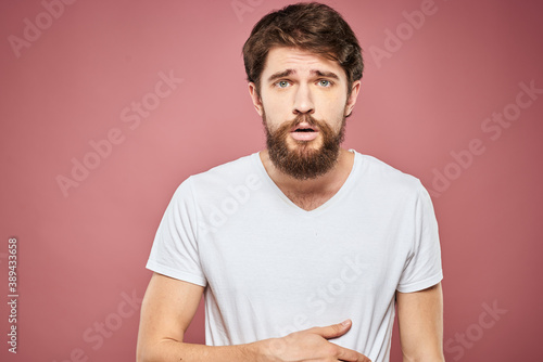 emotional man white t shirt sad facial expression pink background