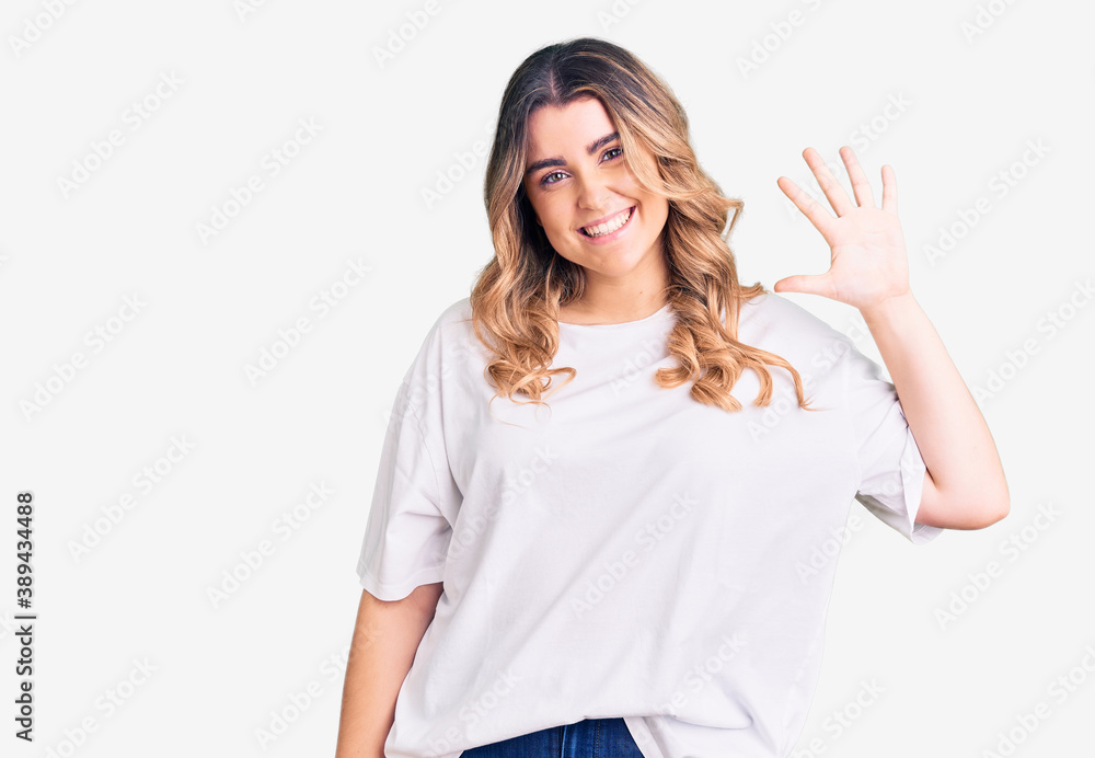 Young caucasian woman wearing casual clothes showing and pointing up with fingers number five while smiling confident and happy. Young caucasian woman wearing casual clothes showing and pointing up with fingers number five while smiling confident and happy.