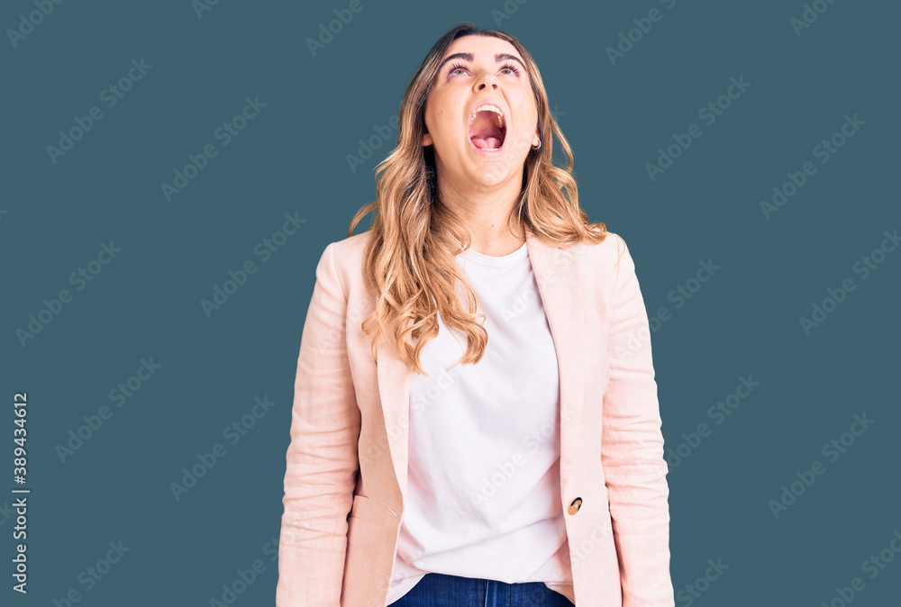 Young caucasian woman wearing business clothes angry and mad screaming frustrated and furious, shouting with anger. rage and aggressive concept. Young caucasian woman wearing business clothes angry and mad screaming frustrated and furious, shouting with anger. rage and aggressive concept.