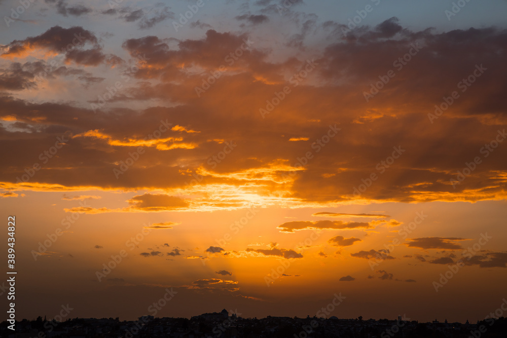 Beautiful Sunset dramatic Clouds, light beam, orange,yellow,purple,blue cloudy sky. 