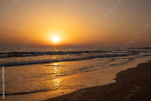 Beautiful Sunset on the Beach with orange sky and yellow sunlight reflection 