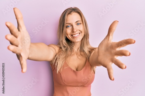 Beautiful caucasian woman wearing casual clothes looking at the camera smiling with open arms for hug. cheerful expression embracing happiness.