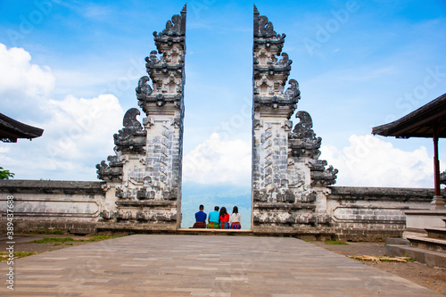 A group tourists taking pictures in Hindu temple heaven's gate wearing Sarong with blue background sky in Bali