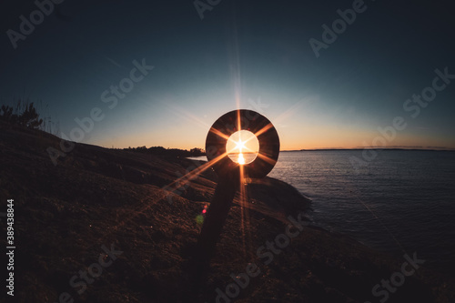 Schilderij op canvas Sunset seen through a ring shaped mooring post