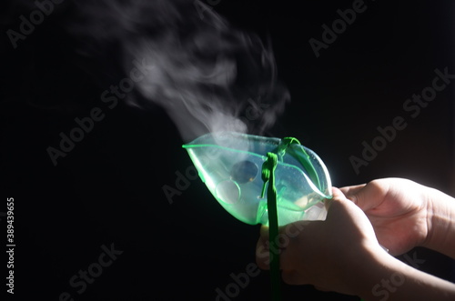A child's hand holding a nebulizer mask photo