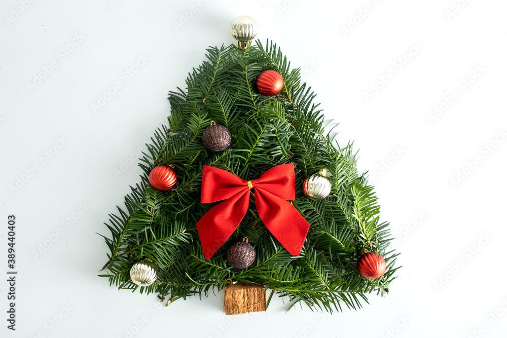 Creative Handmade Christmas tree on a white background, with a red bow and decorative balls