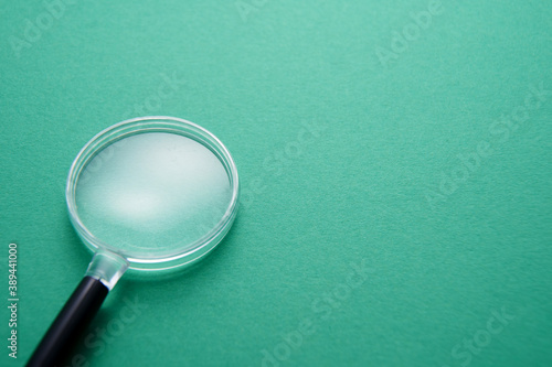 Magnifying glass on green background