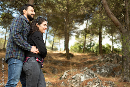 Happy middle-aged couple posing outdoors smiling embraced in a forest on an autumn day © FotoAndalucia