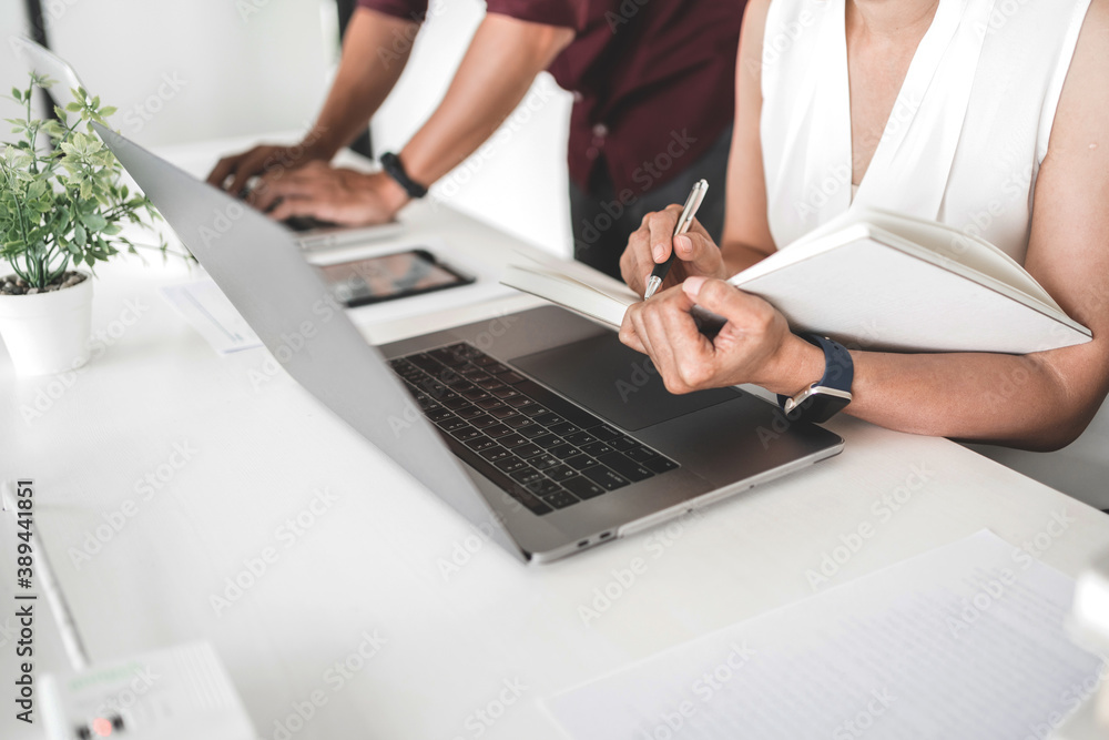 Fototapeta premium University students sitting on the table brainstorming projects working in library.