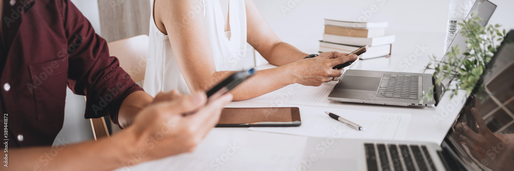 Obraz premium University students sitting on the table brainstorming projects working in library.