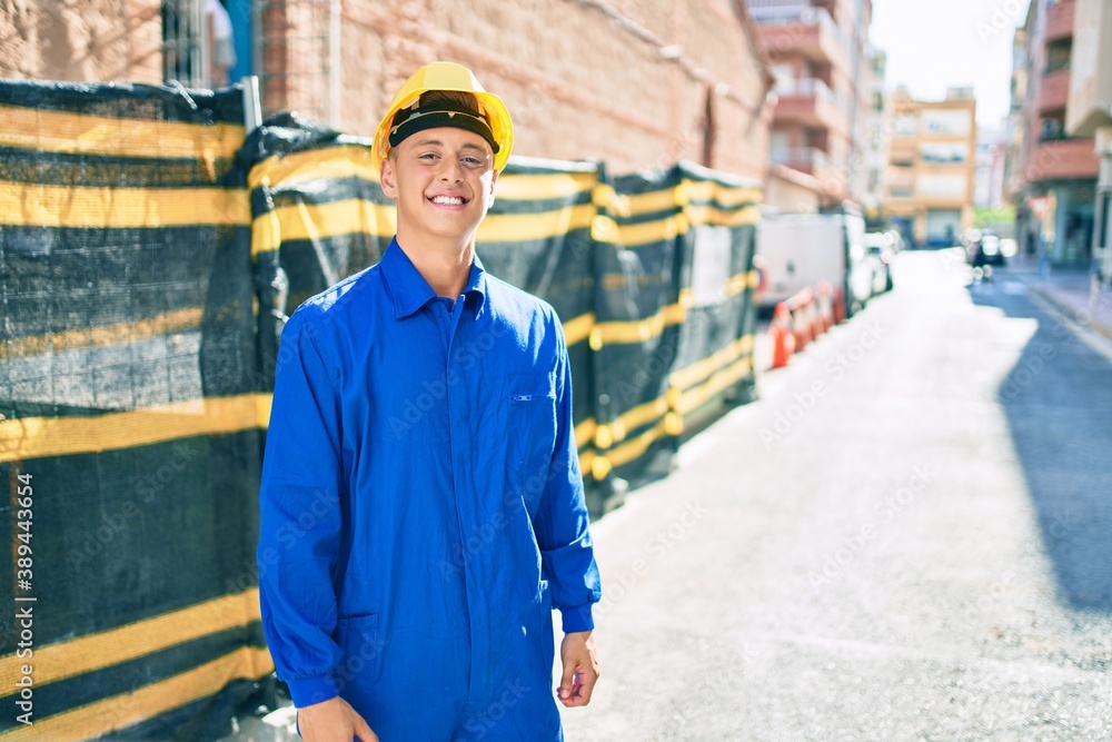 Young hispanic workman smiling happy working at street of city Young hispanic workman smiling happy working at street of city