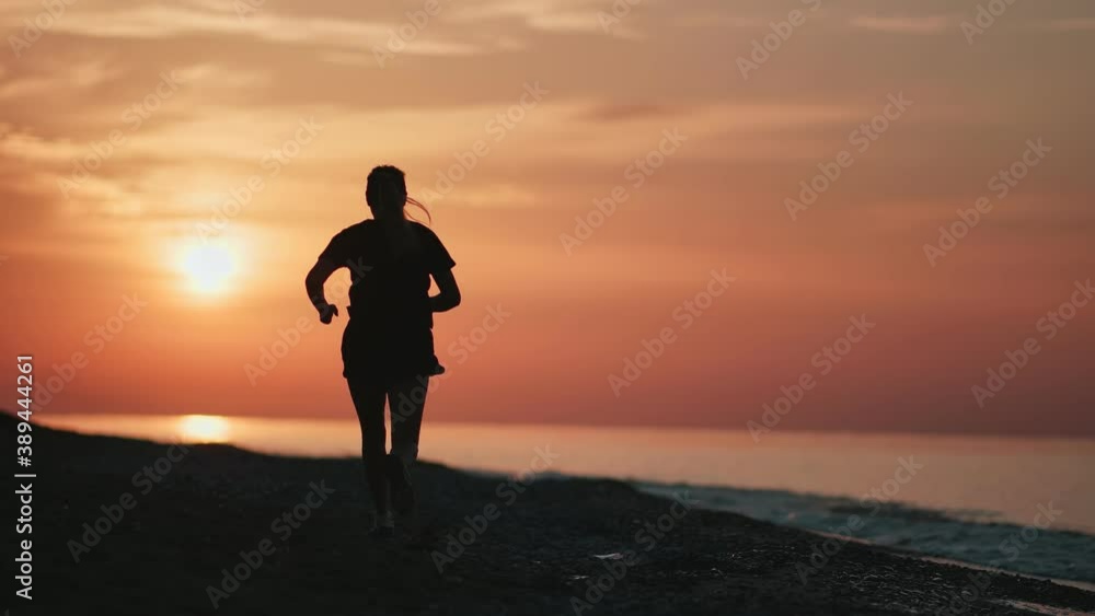 Athletic female running on morning nature beach at sunrise slow motion. Shot with RED camera in 4K Athletic female running on morning nature beach at sunrise slow motion. Shot with RED camera in 4K